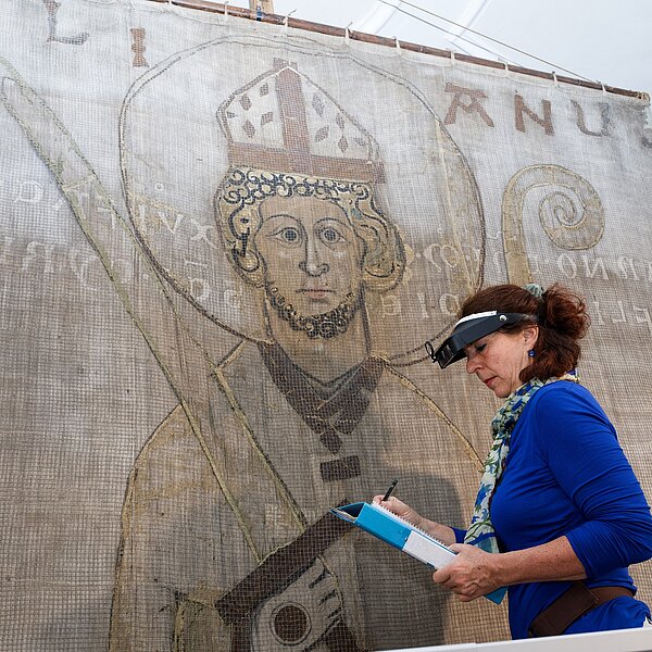 Restauratorin Susanne Wortmann arbeitet am Kiliansbanner.