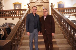 Kunstminister Markus Blume und Museumsdirektor Dr. Richard Loibl stehen auf einer Treppe im Museum für Franken.