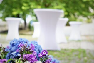 Blumen und Stehtische bei einem Empfang im Museumshof.