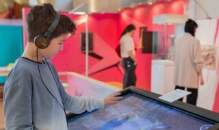 Ein Junge spielt an einem Bildschirm ein interaktives Computerspiel bei der Ausstellung "1525 - Franken fordert Freiheit*en".