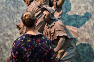 Eine Besucherin betrachtet eine Skulptur im Gartensaal des Museums für Franken.