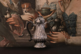Eine Kanne aus Silber vor einem Gemälde
