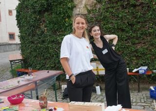 Zwei junge Frauen helfen beim Museumsfest an einer der Mitmachstationen.